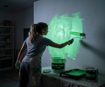 Applying glow paint with roller on walls