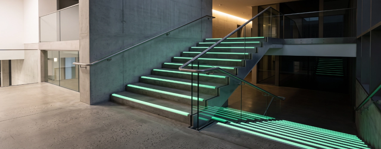 Photorealistic modern commercial staircase with premium aluminium glow in the dark stair nosings installed neatly along each step